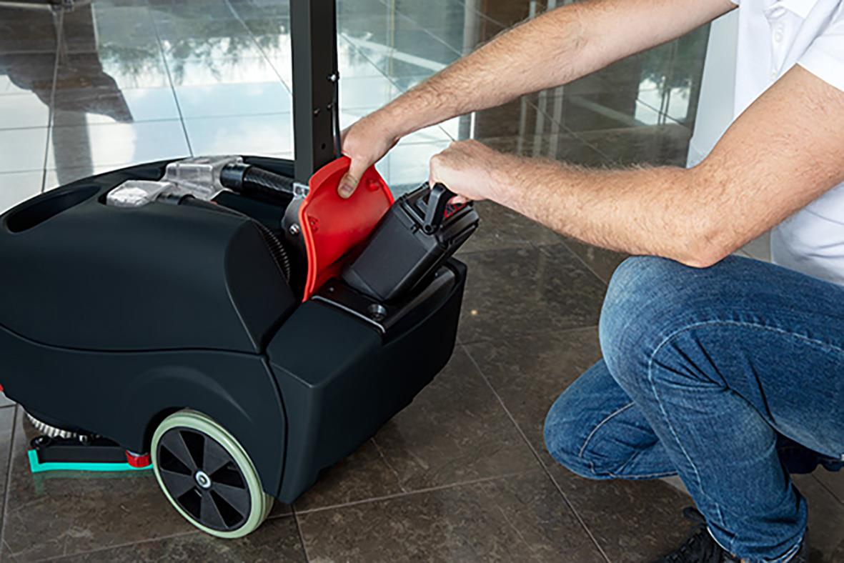 Person som hanterar en kombiskurmaskin Numatic TTB1840NXUB exkl batteri på golvet