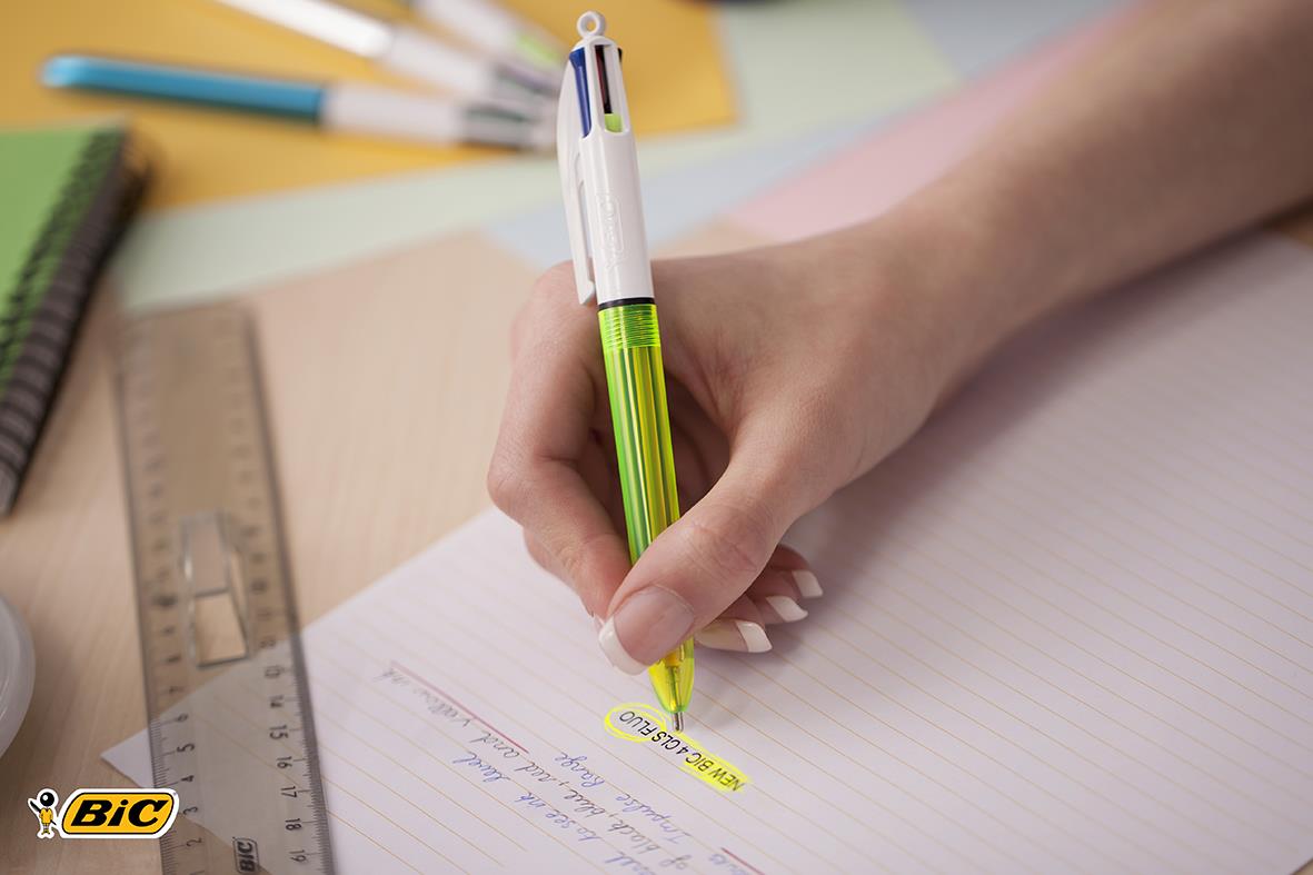 Person som skriver med en Bic Flou 4-Färg kulspetspenna på ett papper