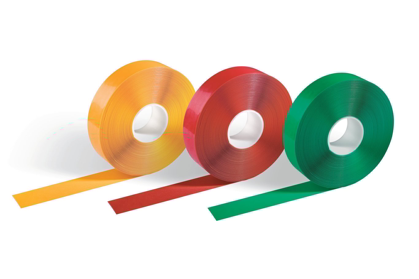 Tre rullar tejp i orange, röd och grön färg