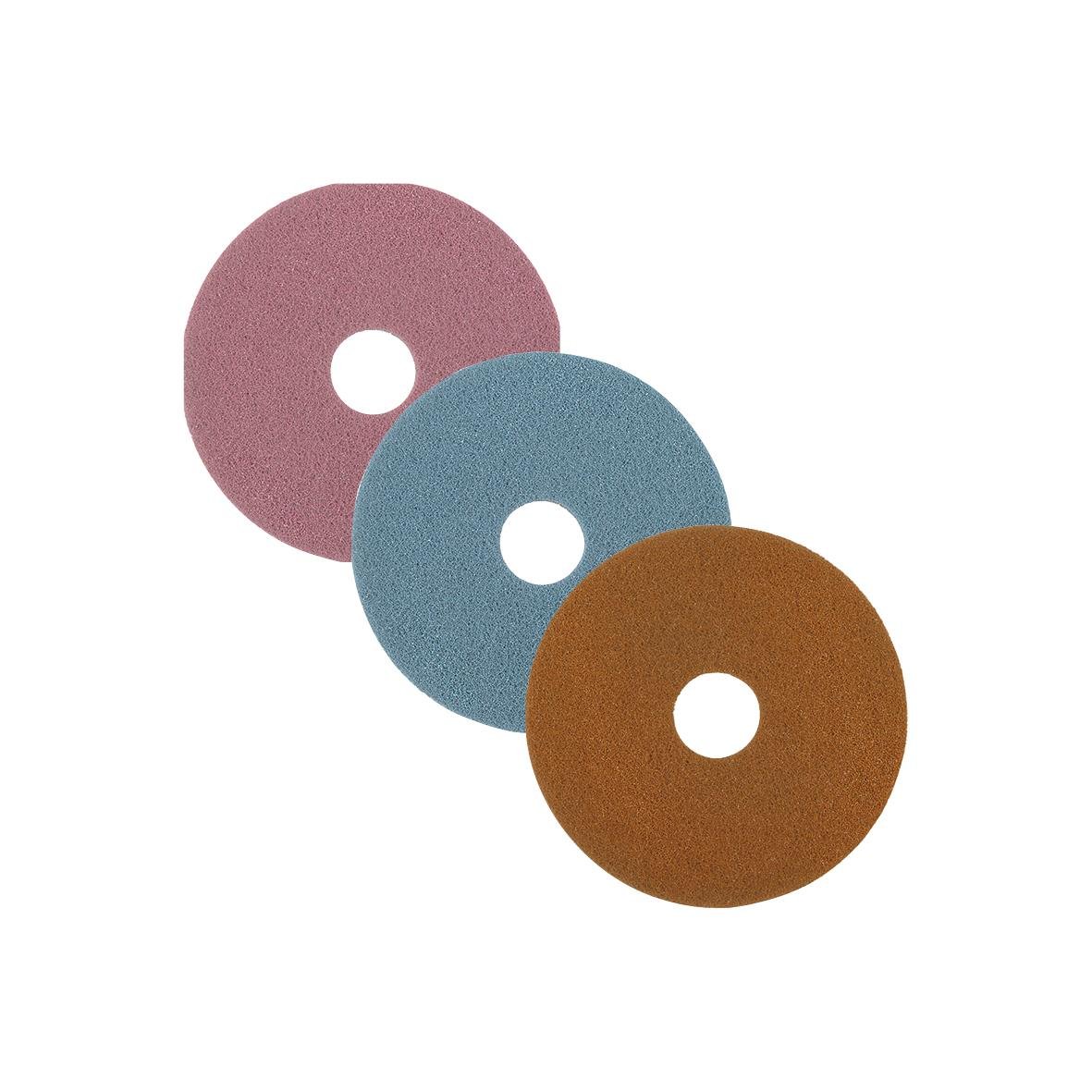 Tre färgade sandpapperrullar i rosa, blå och brunt, placerade i en grupp