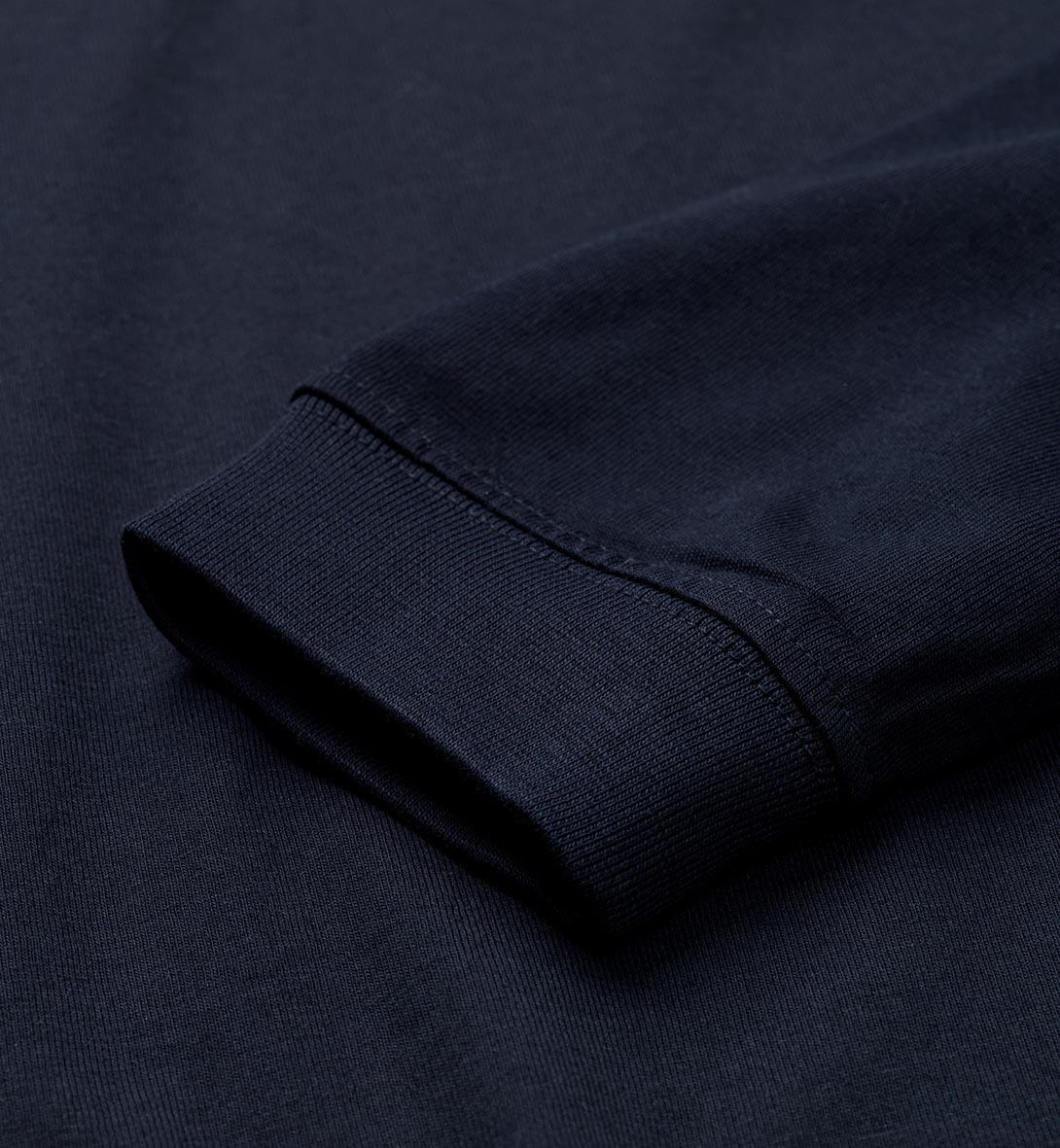 Nära bild av ärmen på marinblå T-shirt med ribbad mudd